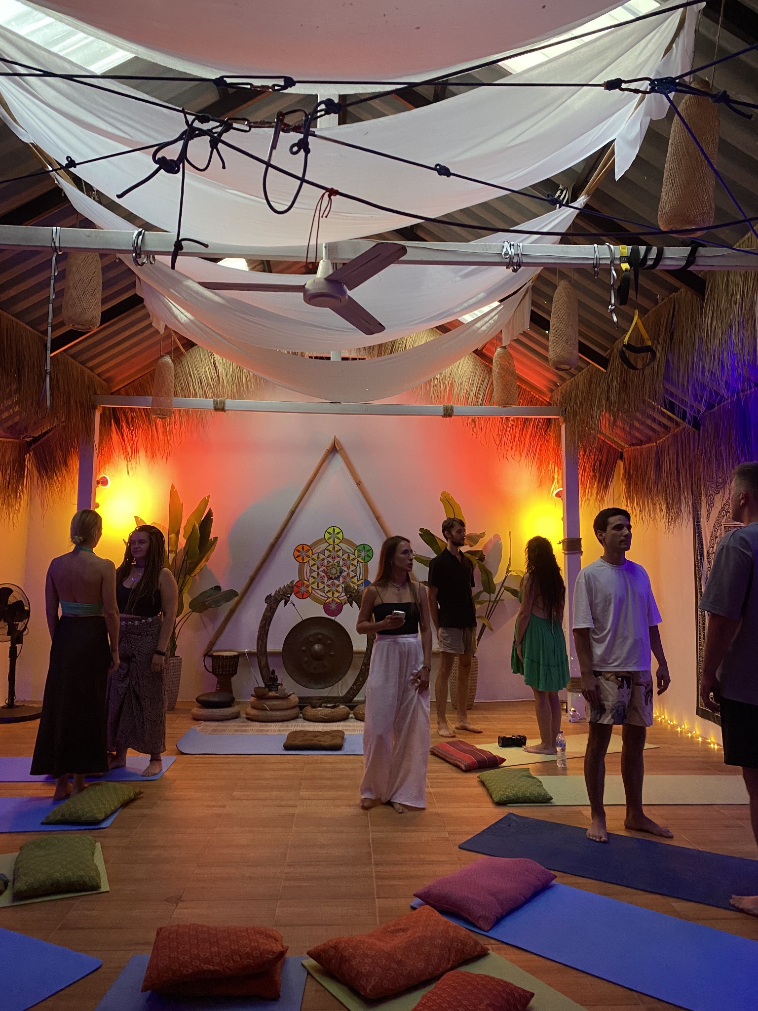 Maria May facilitating a group workshop in a warmly lit practice hall